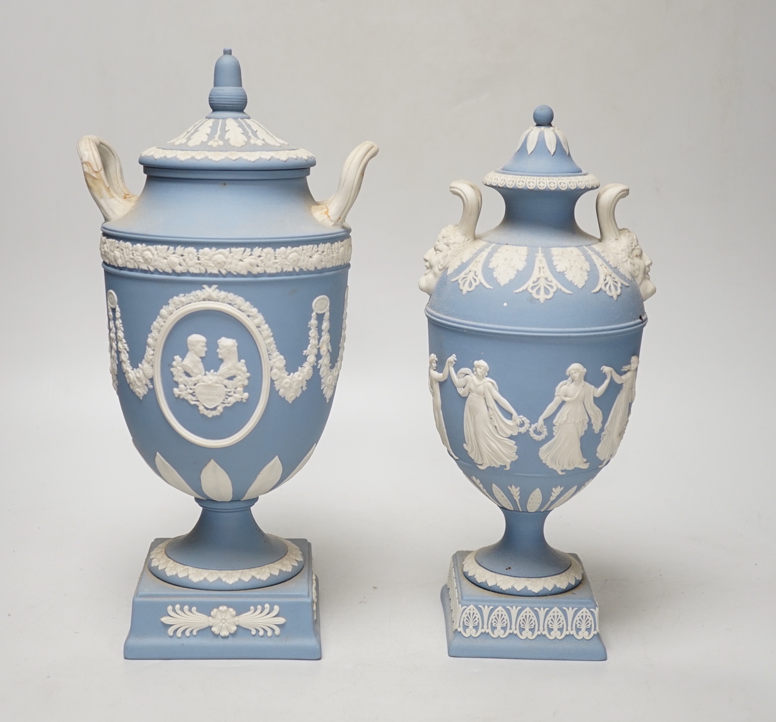 A Wedgwood blue jasper commemorative urn and cover and a similar smaller urn and cover, tallest 31cm